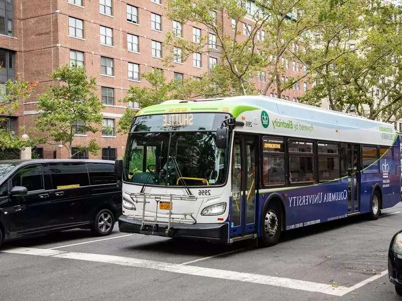 An electric shuttle bus on the street with 哥伦比亚大学 on it